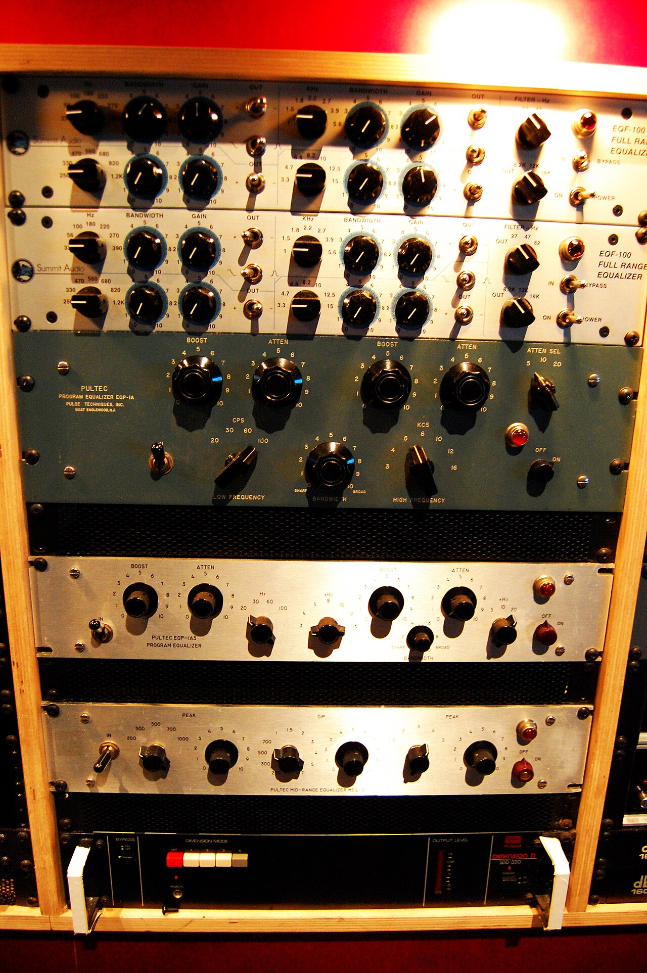 A rack of Pultec EQP-1A and Summit Audio programme equalisers, their boost and attenuate controls visible.